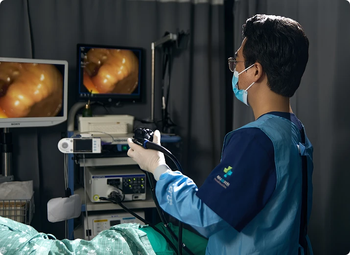 해운대내과 내시경 장비를 들고 검사 중인 김민식 원장님의 측후면 이미지